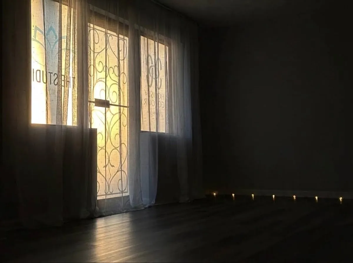 The studio room lit by candles along the floor in the evening